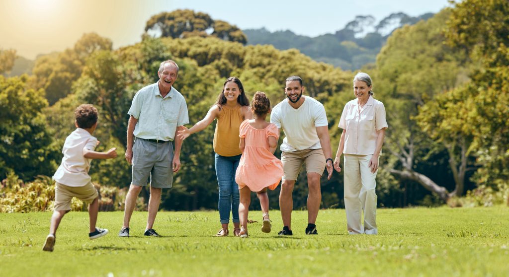 big family, nature park and happy to play with children running on grass with senior grandparents, mom and dad smile in summer sunshine. fun mother, father and open arms to hug kids outdoors together